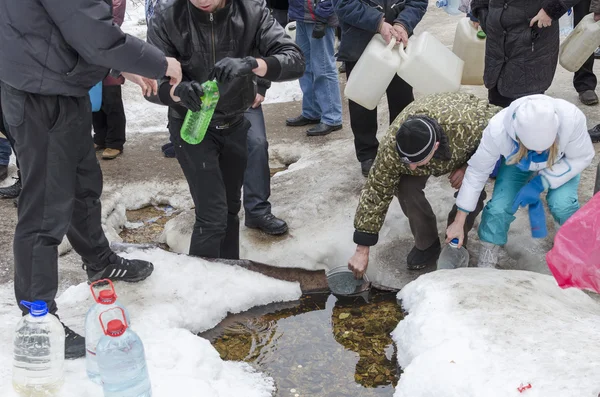 La gente toma agua en el manantial del pozo sagrado en el día de la Epifanía. Región de Irkutsk, Rusia — Foto de Stock