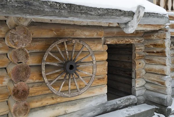 Rueda de carro de madera colgando en la pared de la casa de campo —  Fotos de Stock