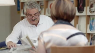 Kağıt Kitaplığı'nda yaşlı karısı ile okuma emekli active senior, yaşlı adam.