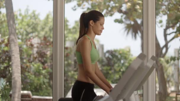 Young exercising and running on treadmill in fitness club — Stock Video