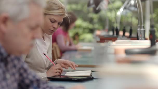 Actieve pensioen, senior man studeren onder jonge en college studenten in bibliotheek — Stockvideo