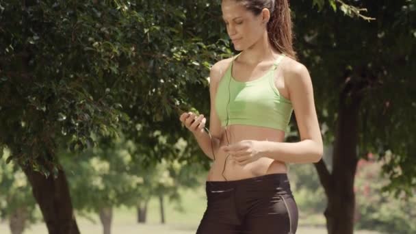 Activité sportive, jolie jeune femme avec lecteur mp3 — Video