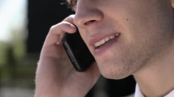 Ung affärsman talar i telefon, närbild av mun — Stockvideo