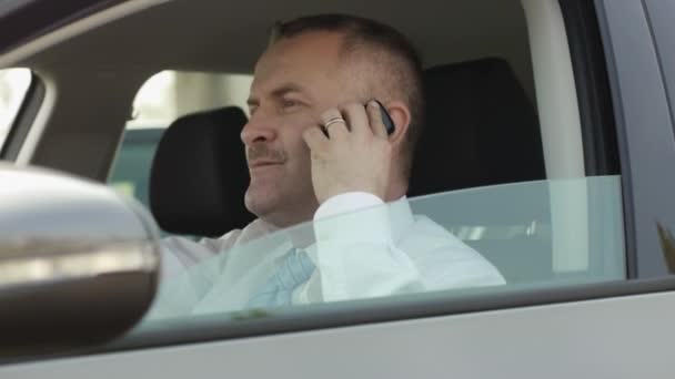 Ο άνθρωπος των επιχειρήσεων στο τηλέφωνο κατά την οδήγηση αυτοκινήτου — Αρχείο Βίντεο