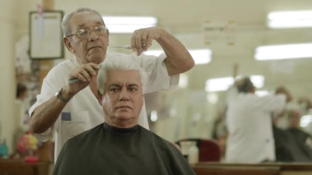 Man getting a haircut by senior barber — Stock Video