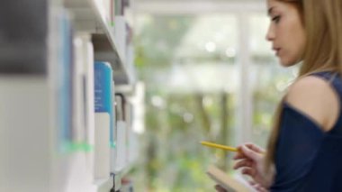 Bayan Üniversite öğrenci alarak kitap kütüphane raf