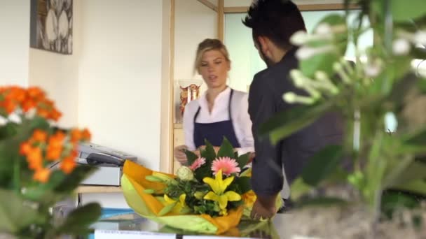Молодая женщина, работающая флористом, дает квитанцию — стоковое видео