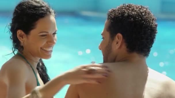 Luna de miel: jóvenes recién casados felices sonriendo y relajándose cerca de la piscina del hotel — Vídeos de Stock