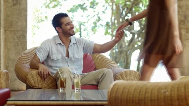 Fiatal házasok hispán pár ül a karosszékben, a szálloda bárjában, és átölelte — Stock videók