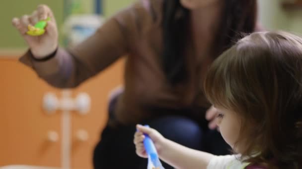 School: teacher feeding young female children during lunch time at kindergarten — Stock Video