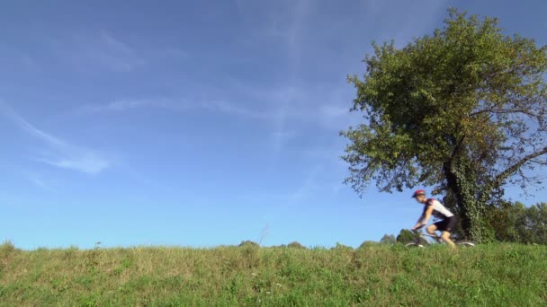 Faji és sport tevékenység: fiatal felnőtt kerékpáros lovaglás kerékpár az országban — Stock videók