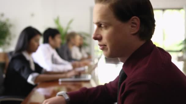 Happy young caucasian businessman smiling at camera during business meeting — Stock Video