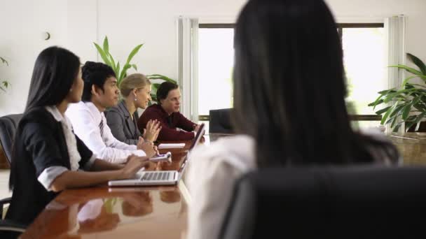 Привлекательная молодая азиатская деловая женщина улыбается на деловой встрече с коллегами — стоковое видео