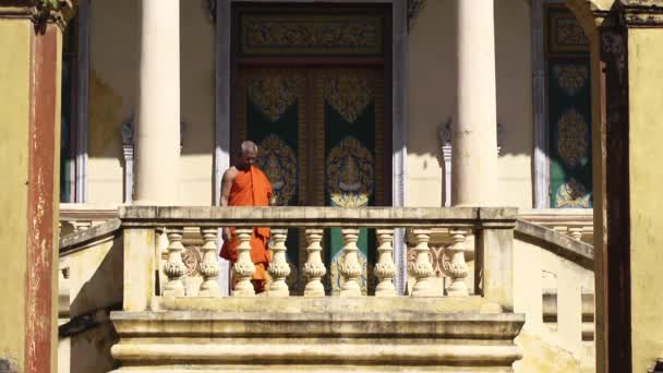 Old Buddhist monk with eyeglasses descending stairs — Stock Video