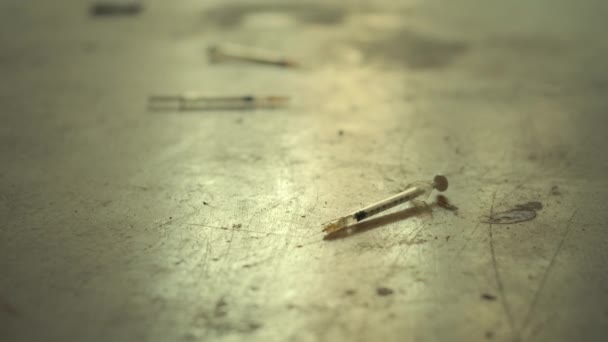 Шприцы, используемые для героина и наркотиков на грязном полу — стоковое видео