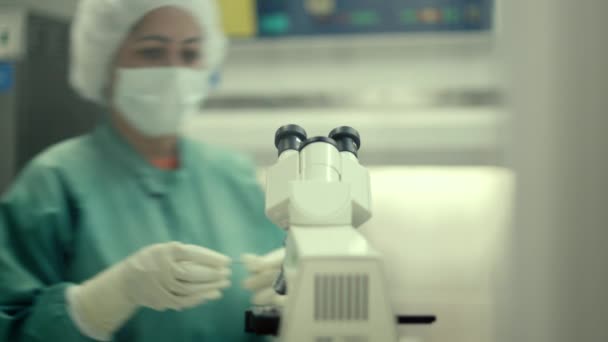 Mulher no trabalho com microscópio em laboratório de biotecnologia — Vídeo de Stock