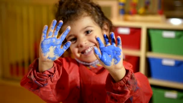 Glückliche Kinder haben Spaß und malen mit den Händen im Kindergarten.