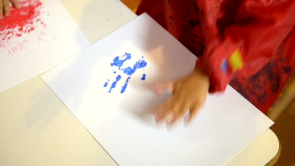 Glückliche Kinder haben Spaß und malen mit den Händen im Kindergarten