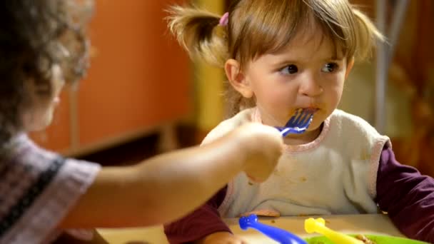 Insegnante donna sorridente alla macchina fotografica e bambini felici che pranzano a scuola . — Video Stock