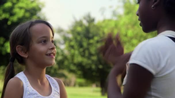 Играют молодые девушки, две счастливые подружки в городском парке — стоковое видео