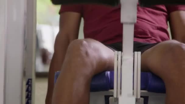 Un joven guapo está haciendo ejercicio en el gimnasio. — Vídeos de Stock