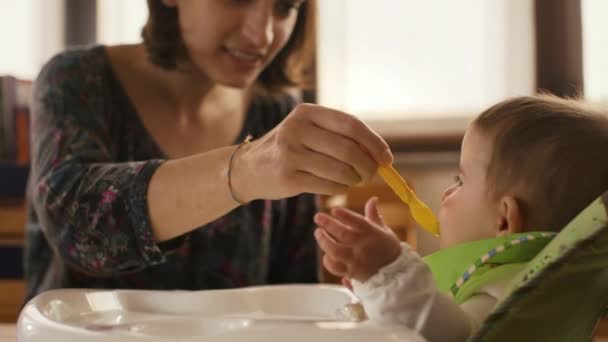 Мать кормит ребенка детским питанием — стоковое видео