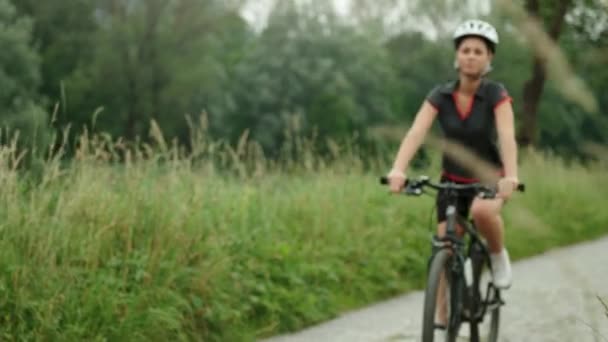 Женщина, юная, развлекающаяся спортивной активностью, красивая девушка на велосипеде и упражнения на велосипеде по проселочной дороге . — стоковое видео