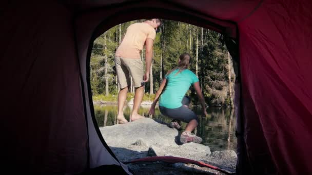 Man and woman camping with tent near mountain lake — Stock Video