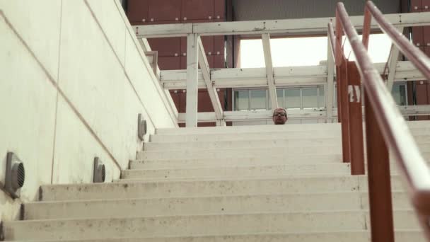 Чоловік на інвалідному візку намагається спуститися сходами в місто . — стокове відео