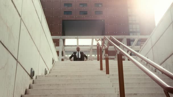 Man on wheel chair trying to descend stairway in town. — Stock Video