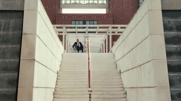 Hombre en silla de ruedas tratando de bajar escaleras en la ciudad . — Vídeos de Stock
