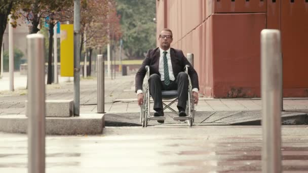 Homem em cadeira de rodas cruzando uma rua da cidade com carro e tráfego . — Vídeo de Stock