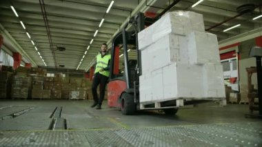 kutuları ve paketleri taşımak için forklift çalışan işçi