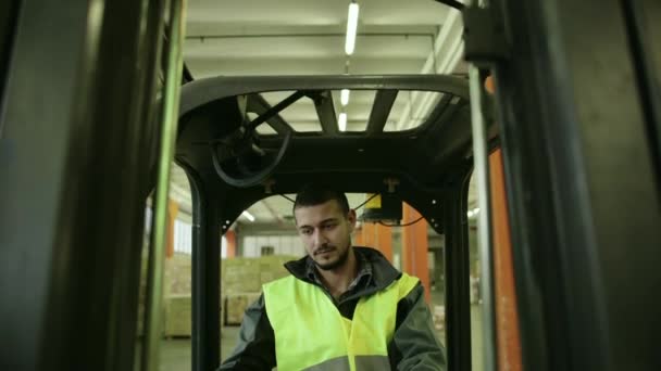 Trabajador manual que opera la carretilla elevadora para mover cajas y paquetes — Vídeos de Stock
