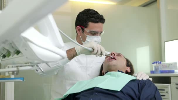 Hombre trabajando como dentista en estudio dental — Vídeos de Stock