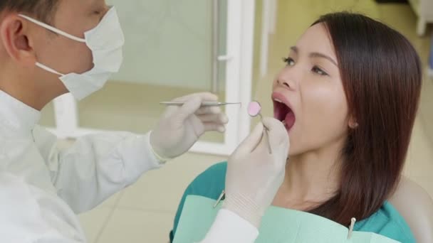 Doktor hostující mladá pacientka v zubaře studio