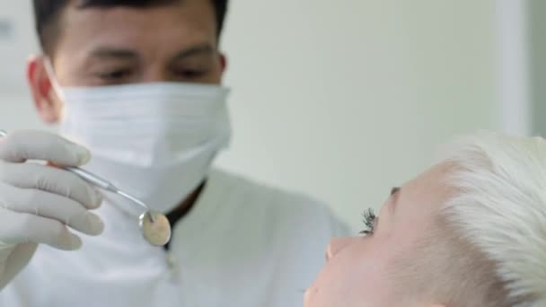 Dentista visitando jovem no estúdio odontológico — Vídeo de Stock