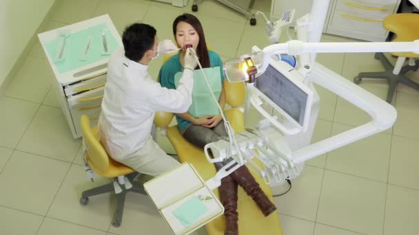 Dentista visitando menina no estúdio dental com ferramentas e equipamentos — Vídeo de Stock