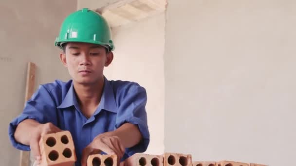 Азиатский человек, работающий с кирпичами — стоковое видео
