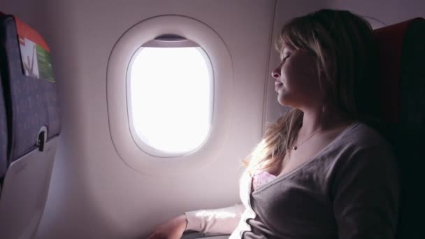 Frau im Flugzeug unterwegs — Stockvideo