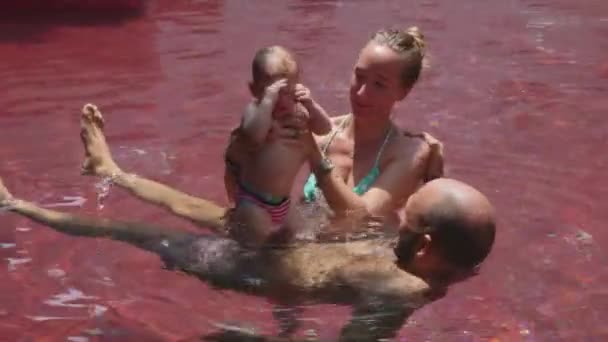 Mom and dad helping daughter  to swim — Stock Video