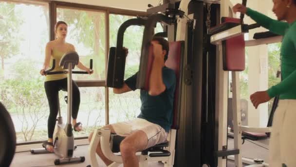 Trainer in gesprek met klanten in fitnessclub — Stockvideo