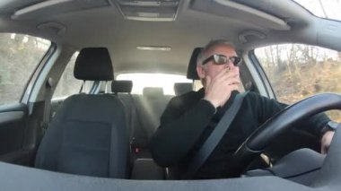 Güzel bir kış günü sokakta araba süren ve sigara içen beyaz bir adam. Beyaz adam yolda ilerliyor, duman üflüyor. Araba şoförü ofise gidiyor. Sağlık sorunları olan kişi