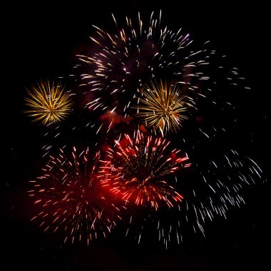 Gece gökyüzünde çeşitli renklerde renkli havai fişekler