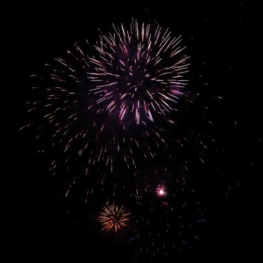 Gece gökyüzünde çeşitli renklerde renkli havai fişekler