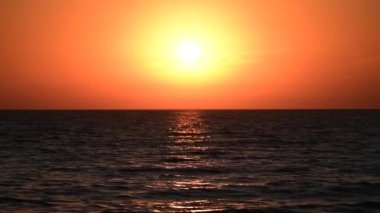 Okyanusun kenarında gün batımının inanılmaz renkli 4K videosu.