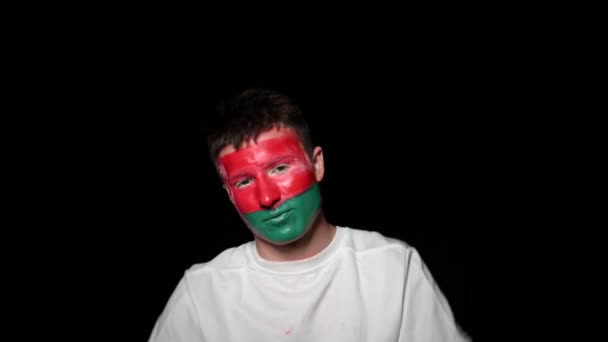 Happy fan celebrate victory of his team. Young man with face painted in national colours. Portrait of a happy man supports his national team at home — Stock Video