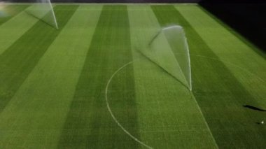 Profesyonel futbol maçından önce futbol sahasını sulamak, bahçe bakımı, futbol maçından önce çim sulama konsepti. 4k yüksek kalitede sinematik HDR görüntüleri 