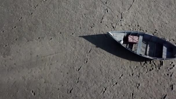 Vista superior del barco en la orilla del mar seco, el calentamiento global y el concepto de sequía. Clima ventoso paisaje desértico con huellas humanas y animales en arcilla seca. Imágenes sin clasificar de drones de alta calidad 4k — Vídeos de Stock