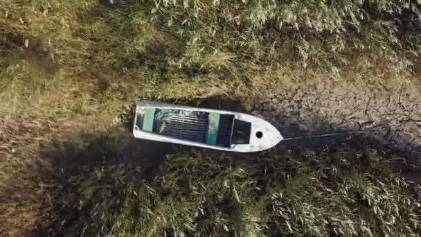 Widok na opuszczoną łódź na brzegu wyschniętego morza, globalne ocieplenie i susza koncepcja. Wietrzny krajobraz pustyni. 4k wysokiej jakości dron niesklasyfikowany materiał — Wideo stockowe